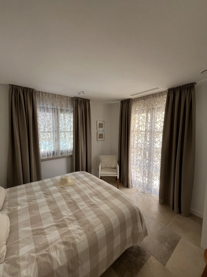 Dormitorio elegante con cortinas oscuras a medida y salida a la terraza