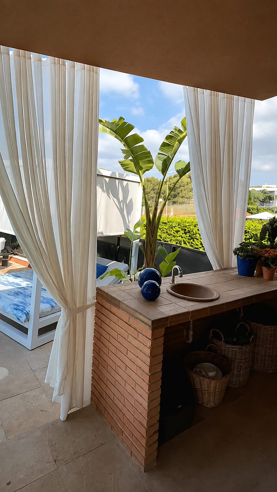Zona chill out en Vilanova con cortinas blancas de exterior a medida